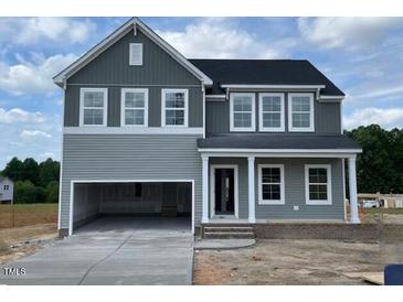 Charming two-story home featuring an open garage, gray siding, and a welcoming front porch with white columns at 54 Grove Township Way, Angier, NC 27501
