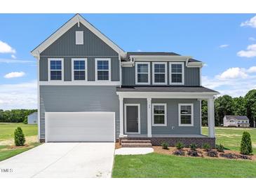 Charming two-story home featuring gray siding, white trim, and a well-manicured lawn at 54 Grove Township Way, Angier, NC 27501