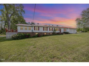 Charming single-story home featuring a metal roof, white siding, and well-maintained lawn at 545 Billy Fitts Rd, Siler City, NC 27344