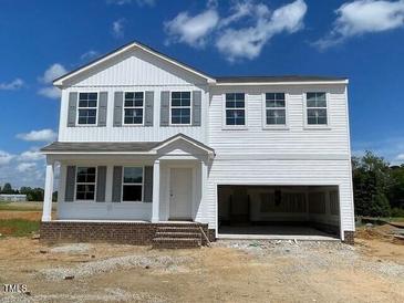 Charming two-story home with a welcoming front porch and an attached two-car garage at 59 Grove Township Way, Angier, NC 27501