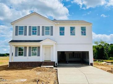 New construction two-story home featuring a white exterior, gray shutters, and a two-car garage under a cloudy blue sky at 59 Grove Township Way, Angier, NC 27501
