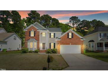 Charming two-story home with brick and siding, a well-manicured lawn, and an attached two-car garage at 6101 Clarks Fork Dr, Raleigh, NC 27616