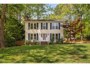Charming two-story home with a well-manicured lawn and blue shutters adding a touch of classic elegance at 7433 Deer Track Dr, Raleigh, NC 27613