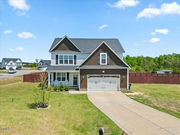Charming two-story home boasts a manicured lawn, two-car garage, and inviting front porch at 85 Sun Mdw Cir, Benson, NC 27504