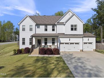 Charming two-story home featuring a three-car garage and beautifully landscaped front yard with attractive shrubbery at 8812 Green Arbor Ct, Wake Forest, NC 27587