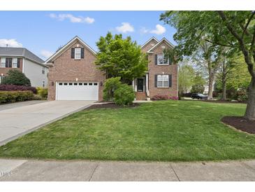 Charming two-story brick home with a well-manicured lawn and a two-car garage at 9100 Dansforeshire Way, Wake Forest, NC 27587