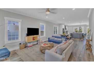 Open-concept living room features a cozy seating area, natural light, and seamless access to dining and kitchen areas at 1008 Holloway St, Durham, NC 27701