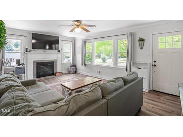 Bright living room featuring a fireplace, large windows and cozy seating area at 1017 Southerlund Rd, Garner, NC 27529