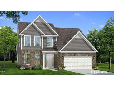 Charming two-story home featuring a mix of stone and siding, complemented by a well-manicured lawn and landscaping at 1028 Channel Drop Lp, Zebulon, NC 27597