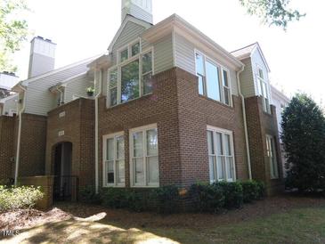 Brick townhome featuring multiple windows, neutral siding, landscaped lawn, and a covered doorway entrance at 1062 Washington St # 201, Raleigh, NC 27605
