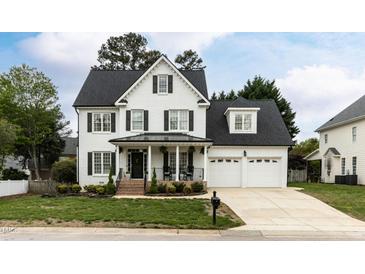 Beautiful two-story home with a white brick exterior, dark shutters and a well-manicured front yard at 10709 Thornbury Crest Ct, Raleigh, NC 27614