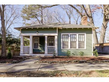 Charming green home with white trim, front porch and landscaped yard at 1105 W Lenoir St, Raleigh, NC 27603