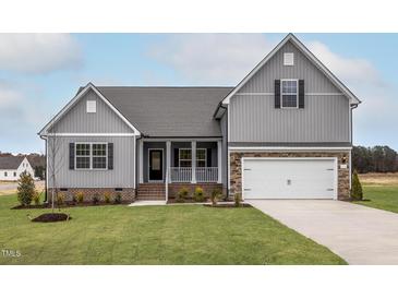 Charming two-story home with a landscaped yard, covered porch, and two car garage at 11430 International Dr, Middlesex, NC 27557