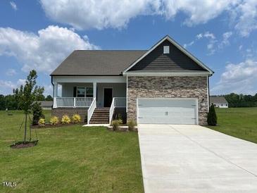 Charming single-story home featuring a stone facade, attached two-car garage, and well-manicured front lawn at 11450 International Dr, Middlesex, NC 27557