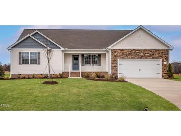 Charming single-story home boasts stone accents, an attached garage, and a well-manicured front lawn at 11682 International Dr, Middlesex, NC 27557