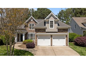 Charming stone and siding home boasts a manicured lawn and two-car garage at 1545 Heritage Links Dr, Wake Forest, NC 27587