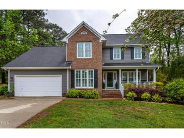 Charming two-story home with a brick and gray facade, lush landscaping, and a welcoming front porch at 1809 Green Ford Ln, Apex, NC 27502