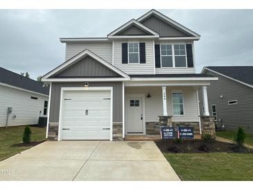 Charming two-story home featuring a single-car garage and classic architectural details, enhanced by a manicured front yard at 244 Bluejay St, Clayton, NC 27520