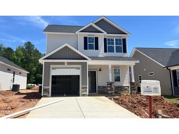 Charming two-story home featuring a gray and white color scheme, black shutters, and an attached garage at 244 Bluejay St, Clayton, NC 27520
