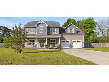 Charming two-story home with a well-manicured lawn and a two-car garage at 28 Lee Woods Dr, Clayton, NC 27520