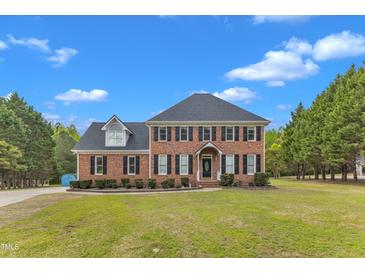 Charming two-story brick home with a manicured lawn and lush greenery at 2804 Brenfield Dr, Raleigh, NC 27606