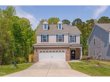 Charming two-story home featuring a brick-accented garage and dormer windows at 3011 Ginger Hill Ln, Durham, NC 27703