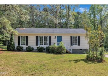 Charming single-story home with blue front door, black shutters, and a lush lawn at 308 Plaza Dr, Garner, NC 27529