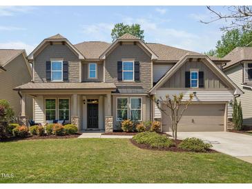 Charming two-story home with a manicured lawn, inviting entrance, and an attached two-car garage at 521 Wildwood Farm Way, Holly Springs, NC 27540