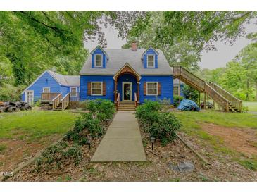 Charming blue two-story home featuring a well-maintained yard and inviting entrance at 6238 Old 421 Rd, Liberty, NC 27298