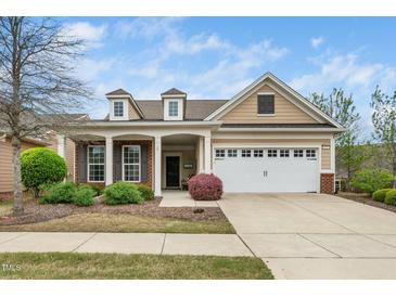 Charming single-Gathering home featuring a two-car garage, dormer windows, and manicured landscaping at 833 Gaston Manor Dr, Durham, NC 27703
