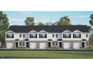 Charming townhouse exterior featuring stone accents, attached garages, and manicured landscaping at 102 Red Maple St, Sanford, NC 27332