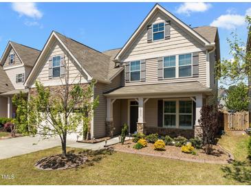 Charming two-story home with a stone facade, covered porch, and landscaped front yard at 1033 Laredo Ln, Durham, NC 27703