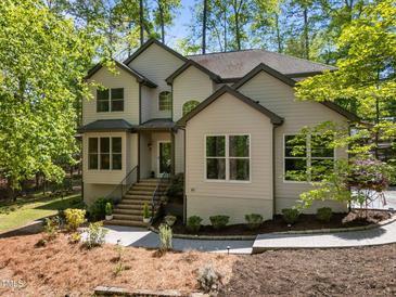 Beautiful two-story home boasts manicured landscaping, a welcoming entrance, and a charming facade, nestled among mature trees at 107 Deer St, Carrboro, NC 27510