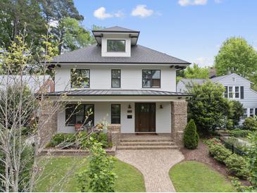 Charming two-story home featuring a manicured lawn, brick pathway, and inviting front porch at 1306 Mordecai Dr, Raleigh, NC 27604