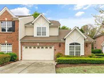 Charming two-story home with a brick and beige exterior and a well-manicured front lawn at 13338 Ashford Park Dr, Raleigh, NC 27613