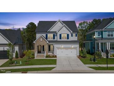 Charming two-story home featuring a brick entryway, white siding, and a well-maintained lawn at 1724 Deacon Falls Way, Wendell, NC 27591