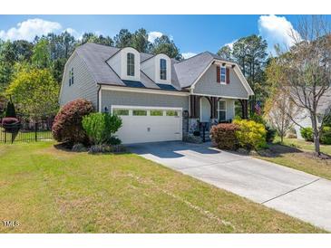 Charming home with a two-car garage, well-manicured lawn, and lovely landscaping under a blue sky at 2008 Stanwood Dr, Apex, NC 27502