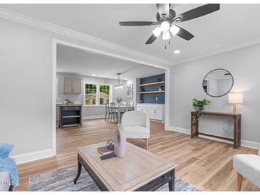 Bright living room featuring hardwood floors, ceiling fan, built-in shelving, and neutral paint at 2712 Cameron Dr, Sanford, NC 27332