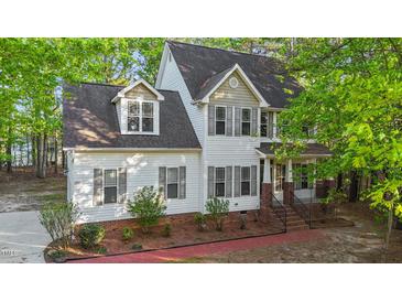 Beautiful two-story home with white siding, grey shutters, and lush landscaping at 286 Trillium Way, Clayton, NC 27527