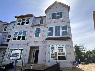 Unfinished new home exterior with visible framework, large windows, and modern architectural details in a residential area at 311 Chesapeake Commons St # 101, Garner, NC 27529
