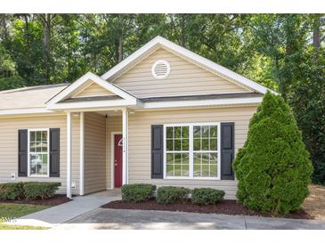 Charming single story home with tan siding, black shutters, a red door, and attractive landscaping at 411 B Aversboro Rd, Garner, NC 27529