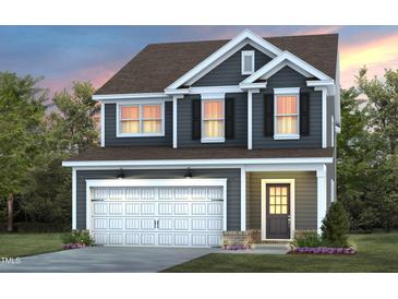 Charming two-story home featuring a white garage door, black shutters, and a well-maintained lawn at 433 Providence Springs Ln, Fuquay Varina, NC 27526