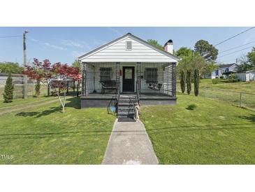Charming single story home featuring a cozy front porch, beautiful lawn, and an inviting walkway at 729 S Carolina Ave, Henderson, NC 27536