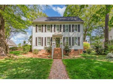 Charming two-story home with black shutters, a brick foundation, and a brick walkway leading to the front door at 8805 Mourning Dove Rd, Raleigh, NC 27615