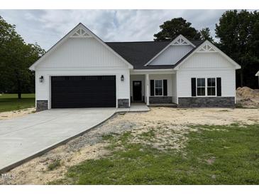 Beautiful new construction home with black garage door and stone veneer details at 1008 Peedin Rd, Selma, NC 27576