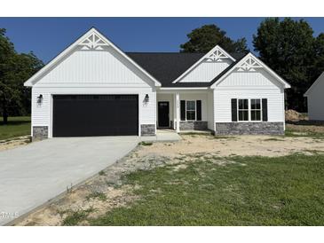 Charming new construction home with a dark garage door, stone accents, and beautiful architectural detailing at 1008 Peedin Rd, Selma, NC 27576