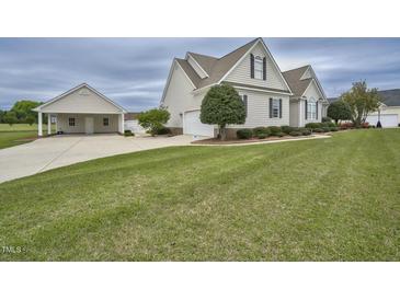 Charming home featuring a large manicured lawn, attached garage, and separate carport at 1454 Spring Pond Rd, Nashville, NC 27856