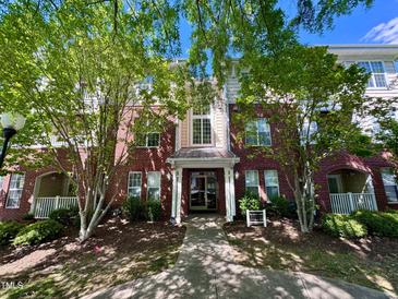 Charming brick condo building exterior with lush green trees and well-maintained landscaping at 1521 Providence Glen Dr # 1521, Chapel Hill, NC 27514