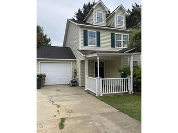Inviting two-story home featuring a covered front porch, attached garage, and well-maintained yard at 158 Randolph Dr, Clayton, NC 27520