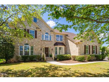 Charming two-story brick home featuring a lush front yard and inviting front entrance at 1602 Eagle Lodge Ln, Durham, NC 27703